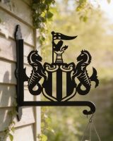 Digital illustration of Steel Newcastle United Crest Hanging Basket Bracket mounted on a shed