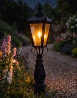 Digital Illustration of the 105cm "Crown Riversham" Black Victorian Patio Lamp Post Set Positioned on a Flowery Gravel Drive Entranceway Whilst Lit up at Night