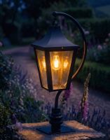 Digital Illustration of the 106cm Black Swan Neck Pillar & Lantern Mounted on a Stone Garden Wall Pillar Whilst Lit up at Night