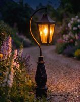 Digital Illustration of the 112cm Black “Lincoln” Swan Neck Lantern & Lamp Post Placed next to a Flowery Gravel Driveway Entrance Whilst Lit up at Night