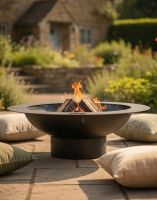 Digital Illustration of the 120cm Curved Steel Bowl Fire Pit Fully Lit with a Rustic Cottage in the Background