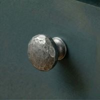 Digital Illustration of the 33mm Hammered Cast Iron Cabinet Knob Mounted on a Dark Blue Cupboard Door