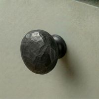Digital Illustration of the 33mm Hammered Steel Cabinet Knob Mounted on a Green Cupboard Door