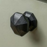 Digital Illustration of the 39mm Steel Beeswax Octagonal Cabinet Knob Mounted on a Sage Green Cupboard Door