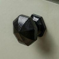 Digital Illustration of the 39mm Steel Powder Coated Octagonal Cabinet Knob Mounted on a Green Cupboard Door