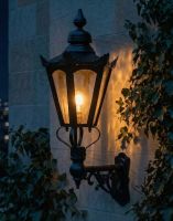 Digital Illustration of the 98 x 46cm Black Hexagonal Wall Lantern on an Ornate Bracket Lit up at Night