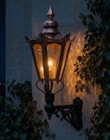 Digital Illustration of the 98 x 46cm Copper Hexagonal Wall Lantern on Ornate Bracket Lit up at Night 