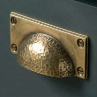 Digital Illustration of the Aged Brass Rectangular Drawer Pull with Curved Hammered Handle Mounted on a Blue Cupboard