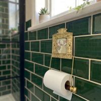 Digital Illustration of the Brass Version of the Globe Toilet Fixture Holding Toilet Roll from an Angled View