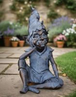 Digital illustration of the Bronze and Verdigris "Reminiscing Pixie" Resin Garden Sculpture Sat on a Garden Patio by the Edge of a Lawn