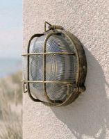 Digital Illustration of the Nautical Round "Cosby" Bulkhead Wall Light in an Antique Brass Finish Mounted on a Cream Coloured Textured Wall