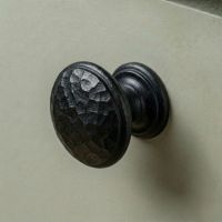 Digital Illustration of the Small Beeswax Beaten Iron Cupboard Knob Mounted on a Sage Green Cupboard