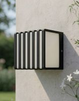 Digital Illustration of the "Tilstone" Garden Wall Light with Aluminium Grill Detailing Mounted on a White Sunny Garden Wall with White Flowers in the Foreground