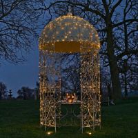 digital representation at night lit up with fairy lights Ornate ironwork gazebo in garden