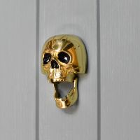 Solid brass unique gothic door knocker on grey door