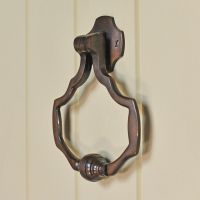 Unique Antique copper door knocker on cream door Unique Antique copper door knocker on cream door