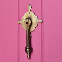 Antique Brass pendulum door knocker on pink door Antique Brass pendulum door knocker on pink door
