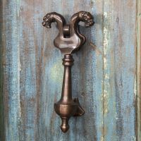 Antique Copper Saber Tooth Door Knocker on Old wooden door