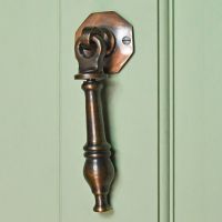 Simplistic door knocker finished in antique copper on green door Simplistic door knocker finished in antique copper on green door