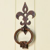 Fleur de lys design door knocker on cream door