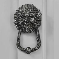 Green Man door knocker finished in black on grey door Green Man door knocker finished in black on grey door