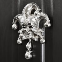 Bright Chrome Jester door knocker on black door Bright Chrome Jester door knocker on black door