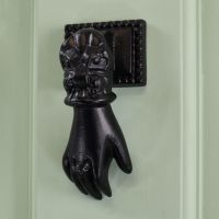Black Hand door knocker on pale green door Black Hand door knocker on pale green door