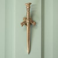 Polished Brass Sword Door Knocker on Pale Green Door Polished Brass Sword Door Knocker on Pale Green Door