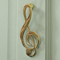 Polished Brass Music Note door knocker on pale green door