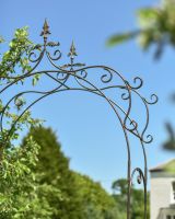 Close up of ornate scrollwork detail on garden rose arch