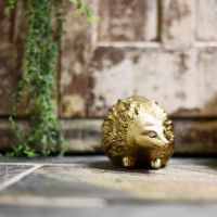Quirky animal hedgehog door stop next to rustic door