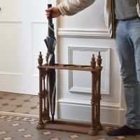Antique Brown Cast Iron Umbrella Holder with Male for scale 