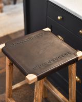 Top of rustic leather and mango wood breakfast bar stool.