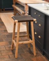 Bar stool with rustic brown leather seating and mango wood.