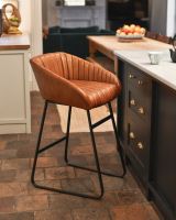 Stylish tan leather stool with iron framework.