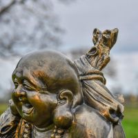 Side View Close-Up of Happy Buddha Bronze Garden Sculpture