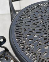 close up of antique bronze table top detail on metal garden table and chairs set