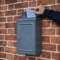 Simplistic Post Box on House Wall in Use