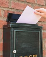 The Antique Green "Oxford" Wall Mounted Post Box with Gold Detailing Showing Posting A Letter The Antique Green "Oxford" Wall Mounted Post Box with Gold Detailing Showing Posting A Letter