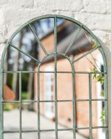 Angled close up of rustic metal patio mirror