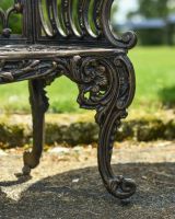 Close up of ornate leg detail on bronze garden bench