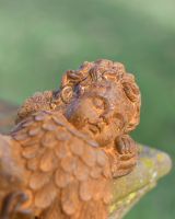 Close up of face detail on rustic finish patio ornament Close up of face detail on rustic finish patio ornament