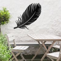 Feather Wall Art in Use in the Garden Above a Wooden Table and Chair Set Feather Wall Art in Use in the Garden Above a Wooden Table and Chair Set