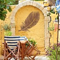 Feather Wall Art in Use on a Yellow Garden Wall