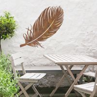 Feather Wall Art in Use in the Garden Above a Wooden Table and Chair Set