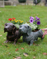 "Digby" the Sausage Dog Cast Aluminium Planter - Copper with flowers in planter stood next to verdigris version