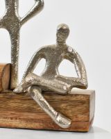 Close up of cast aluminium figure on a mango wood base interior art sculpture Close up of cast aluminium figure on a mango wood base interior art sculpture