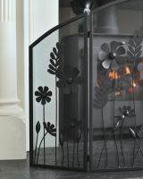 Close up of mesh and flowers detailing on triple fold ornate fire screen Close up of mesh and flowers detailing on triple fold ornate fire screen