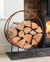 The 69.5cm Copper Contemporary Circular Log Rack & Holder in a Modern Living Room next to a Log Burner - Digital Illustration  