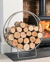 The 69.5cm Pewter Finish Circular Log Rack & Holder Shown up Close next to a Traditional Log Burner Stove - Digital Illustration 